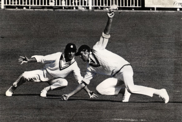 Tony Greig dives in front of Mike Brierley during the Centenary Test at the MCG.