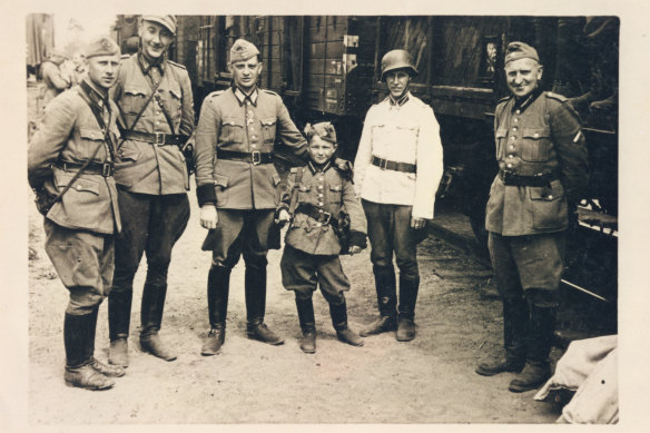 Alex Kurzem with the Latvian police battalion who anointed him as their mascot – miniature uniform and all.