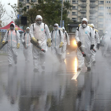 In Taiwan, soliders spray disinfectant in a drill for coping with cluster infections.