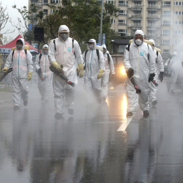 In Taiwan, soliders spray disinfectant in a drill for coping with cluster infections.