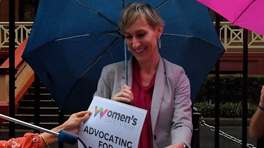 Women's Safety NSW chief executive Hayley Foster holds up a sign at a rally in Sydney against domestic violence.