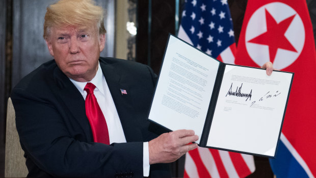 Donald Trump holds up the document he and North Korea's leader Kim Jong-un signed following their historic summit.