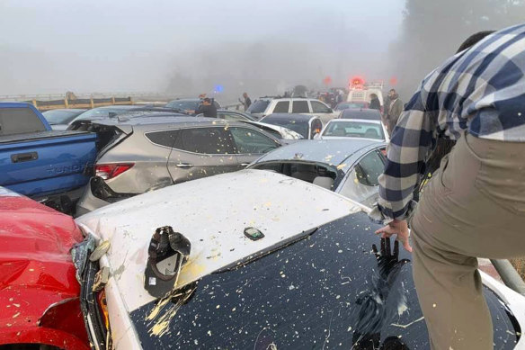 A person climbs over crashed cars at the scene of a multi-vehicle pileup in Virginia.