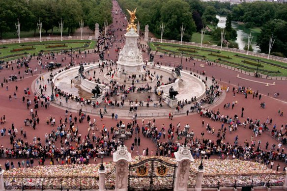 Crowds leave their floral tributes at the  gates of Buckingham Palace.