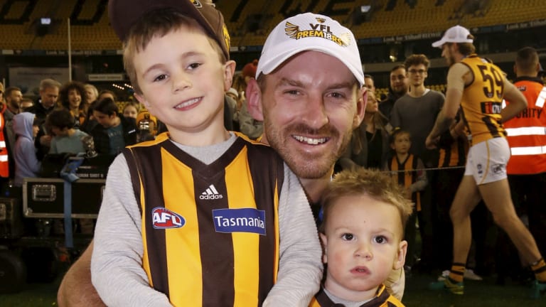 Last hurrah: Veteran Brendan Whitecross with his children after finally scoring a grand final win with the Hawks, in the VFL.