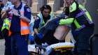 An injured  woman is attended by emergency workers.