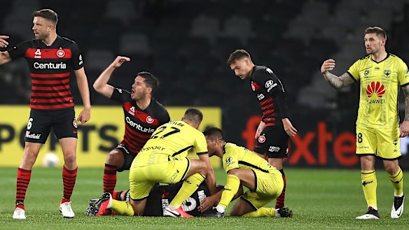Wanderers players call for medical help after Nicolai Muller suffers a concussion against the Phoenix.