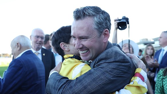 Jockey Craig Williams hugs trainer Adrian Bott.