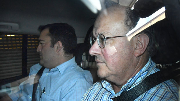 Dr William Russell Massingham Pridgeon (right) is seen being driven into the Brisbane Watchhouse on Friday.