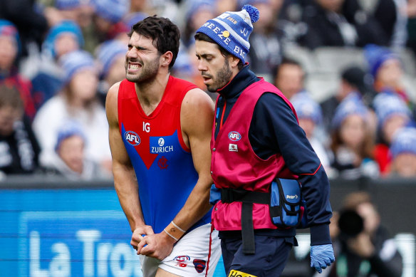 Christian Petracca of the Demons leaves the field injured against Collingwood in Round 13.