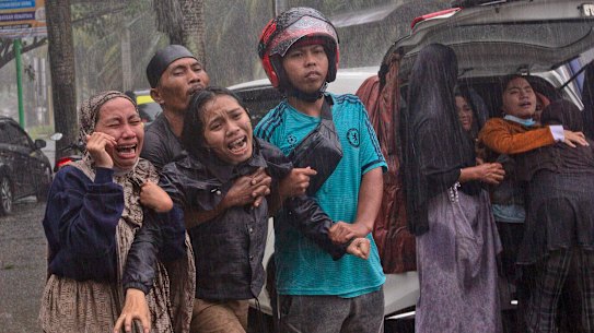 Families grieve as the body of a relative is recovered from the rubble. 