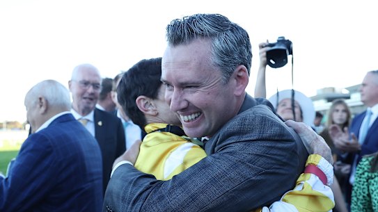 Jockey Craig Williams hugs trainer Adrian Bott.