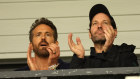 Wrexham co-owner Ryan Reynolds chats with actor Paul Rudd in the stands.