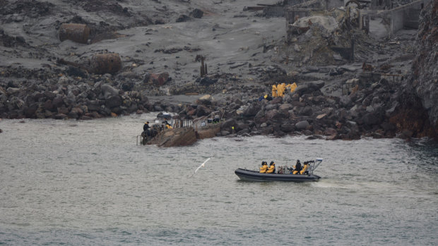 The team, huddled in yellow suits, gather at the entrance to the island on Friday.