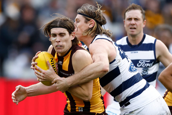 Hawthorn’s Will Day tackled by Geelong’s Mark Blicavs.