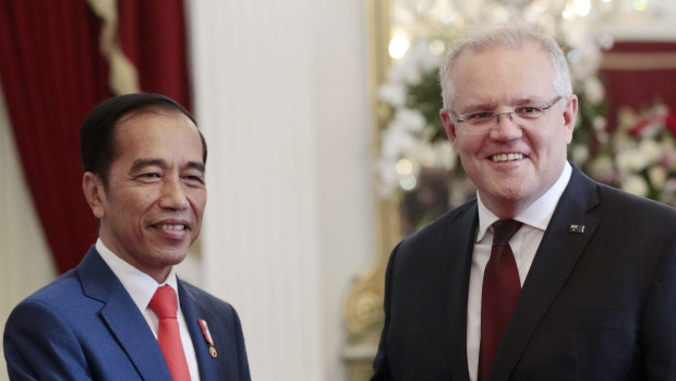 Indonesian President Joko Widodo, left, poses with Australian Prime Minister Scott Morrison for a photo during their meeting ahead of Widodo's inauguration, at Merdeka Palace in Jakarta, Indonesia, Sunday, Oct. 20, 2019. 