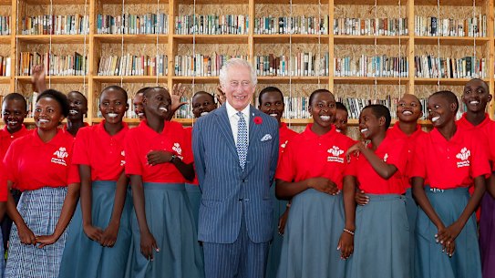 King Charles with students during his visit to the Eastlands Library to learn about a project that restores old libraries and encourages reading among children in the Makadara district of Nairobi.