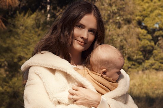 Laura Henshaw, with baby Atlas. Laura wears Max Mara coat. Zara dress and boots. Atlas wears Nature Baby (throughout).