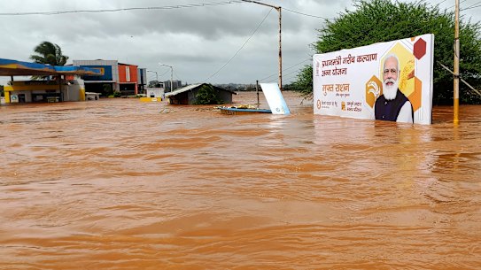 A billboard featuring Prime Minister Narendra Modi is partially submerged in flood waters at Kolhapur in western Maharashtra state, India.