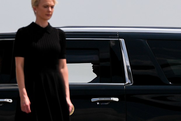 President Donald Trump is seen as his motorcade drives past White House aide Natalie Harp.