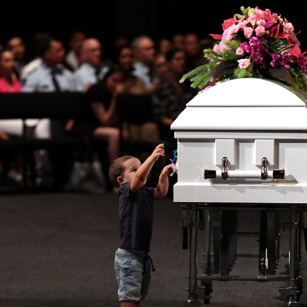 Hannah Clarke's nephew Tyler reaches to the coffin during the funeral for Hannah and her three children Aaliyah, Laianah and Trey.