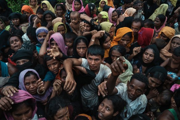 Rohingya refugees from Myanmar clamour for bamboo poles and tarpaulins to build shelters at a new camp near Kutupalong, Bangladesh, in 2017.