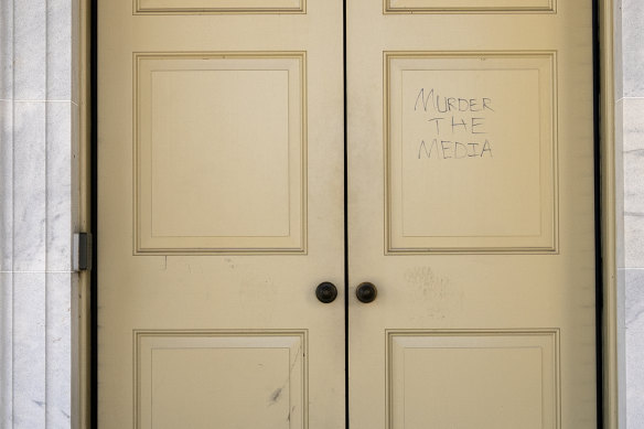 "Murder the Media" is scrawled on a door in the US Capitol building after Trump supporters rioted.