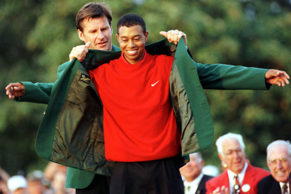 Defending Masters champion Nick Faldo helps Tiger Woods into his green jacket in 1997.