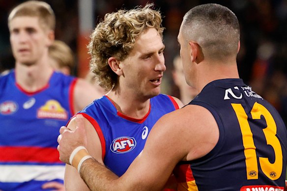 Aaron Naughton congratulates Taylor Walker after the former Crows skipper’s final Adelaide Oval game.