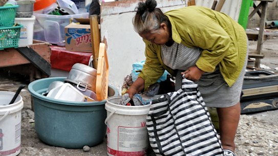A woman who used to run a food store on the Sari Club site collects her belongings in preparation for leaving.