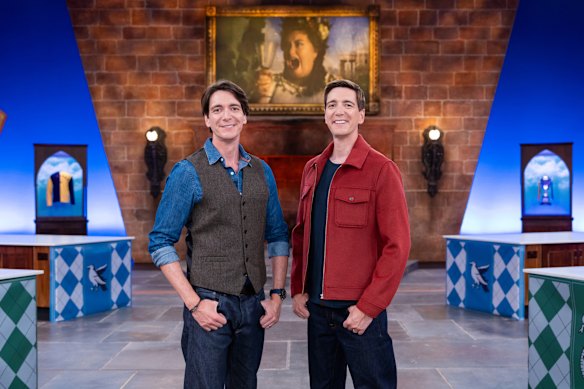 Hosts James Phelps and Oliver Phelps pose on the set of Harry Potter: Wizards of Baking.