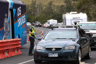 Police stop motorists at a checkpoint in Genoa as they enter Victoria from NSW. 