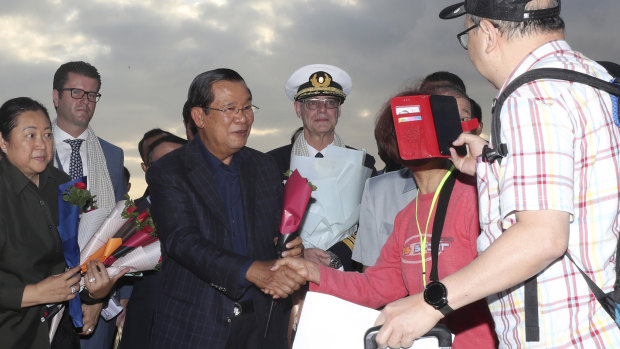 Cambodian Prime Minister Hun Sen greets passengers disembarking from the MS Westerdam, owned by Holland America, at the port of Sihanoukville, Cambodia, last month.