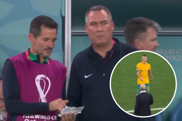 Socceroos assistants Andrew Clark and Rene Meulensteen review the scrap of paper handed to Graham Arnold by Mitchell Duke.