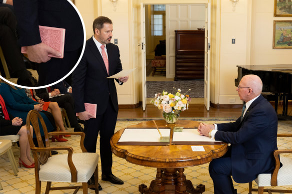 Industry and Science Minister Ed Husic holds a pink Koran during the swearing-in ceremony.