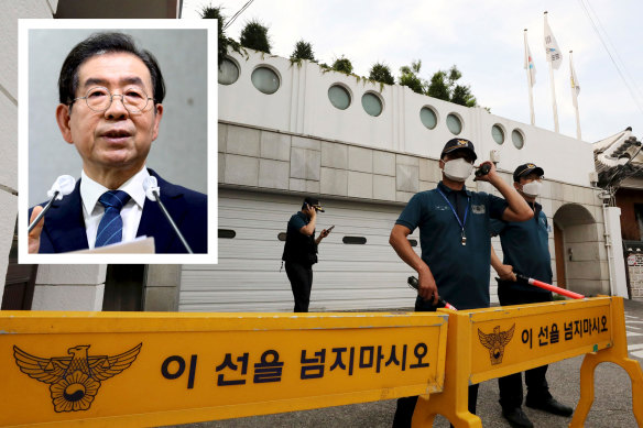 Police officers stand guard in front of the house of Seoul mayor Park Won-soon (inset) in Seoul.