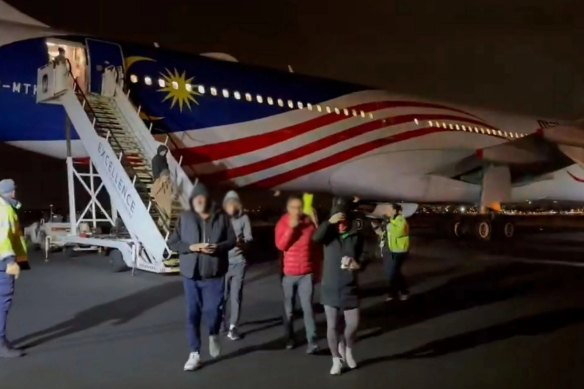 Passengers disembark from Malaysia Airlines flight MH122.