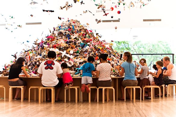 Project: Another Country by Isabel and Alfredo Aquilizan invites gallery goers to make their own airplanes. 