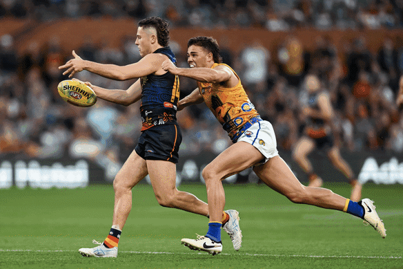 The Crows’ Jake Soligo gets caught holding the ball by Campbell Chesser, of the Eagles on Sunday.