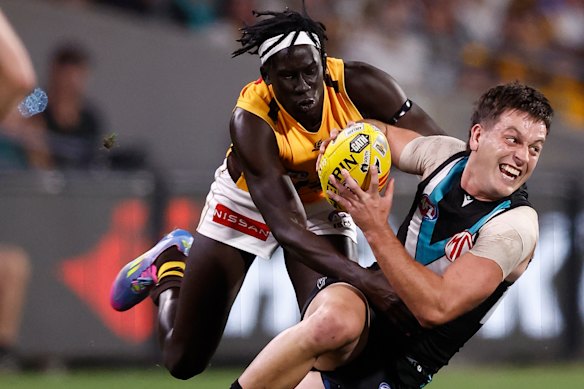 Zak Butters of the Power is tackled by Changkuoth Jiath of the Hawks.