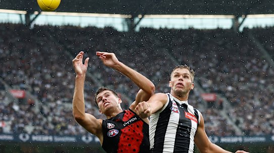 Zach Reid of the Bombers and Dan Houston of the Magpies compete for the ball.