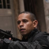 A police officer aims his weapon during a police operation against organised crime in the Mare Complex favela of Rio de Janeiro.