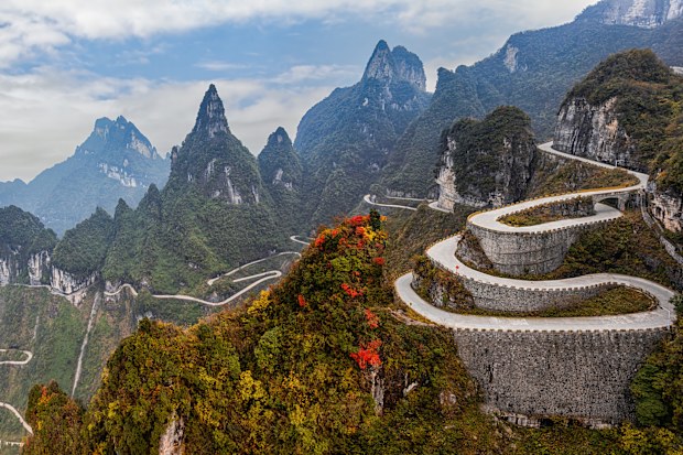 Twisting mountain road weaving misty peaks and lush green slopes in Tianmen Mountain National Park