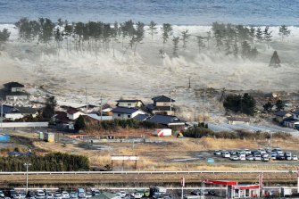 Waves from the March 11, 2011 tsunami hit residences in Natori, in Japan’s Miyagi prefecture.