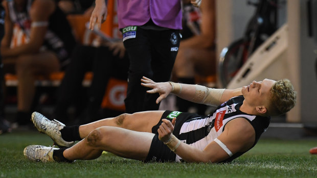 Adam Treloar writhes in pain thanks to his dual hamstring injuries. 