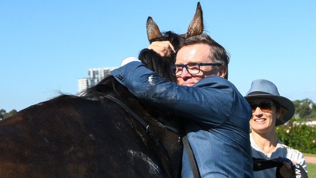 Trainer David Vandyke hugs Alligator Blood.