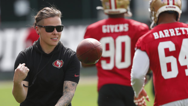 San Francisco 49ers offensive assistant coach Katie Sowers tosses a ball to players during practice for the Super Bowl.