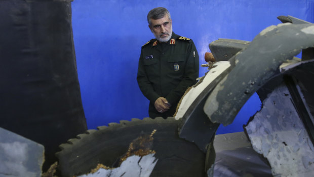 Head of the Revolutionary Guard's aerospace division General Amir Ali Hajizadeh looks at debris from what the division describes as the US drone which was shot down in Tehran in 2019.