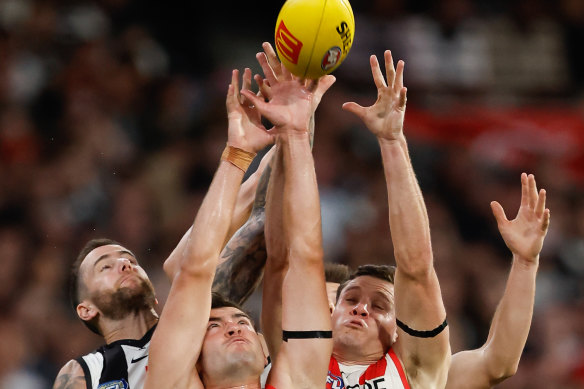 Jeremy Howe of the Magpies, Logan McDonald of the Swans and Hayden McLean of the Swans compete for the ball.