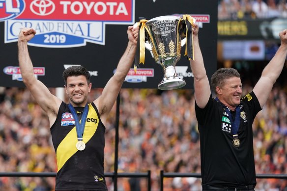 Damien Hardwick, coach of the Tigers and Trent Cotchin of the Tigers hold the premiership trophy aloft after winning the 2019 AFL Grand Final
